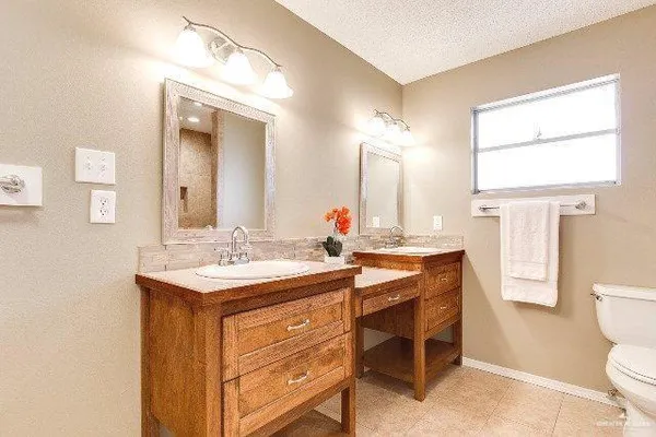 a bathroom with a granite countertop sink a toilet and a mirror