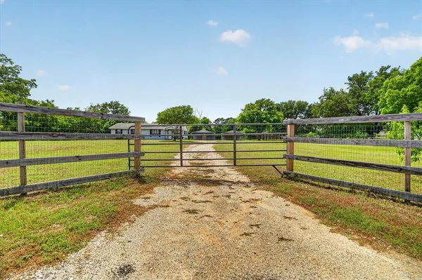 a view of a yard with wooden fence