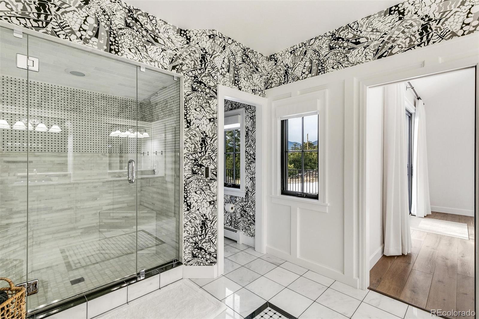 1128 County Road 65 Evergreen, CO 80439 - Photo 16 of 40 a bathroom with a glass shower door