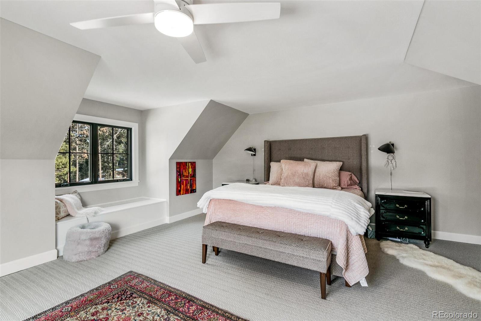 1128 County Road 65 Evergreen, CO 80439 - Photo 22 of 40 a bedroom with a bed and a lamp on dresser