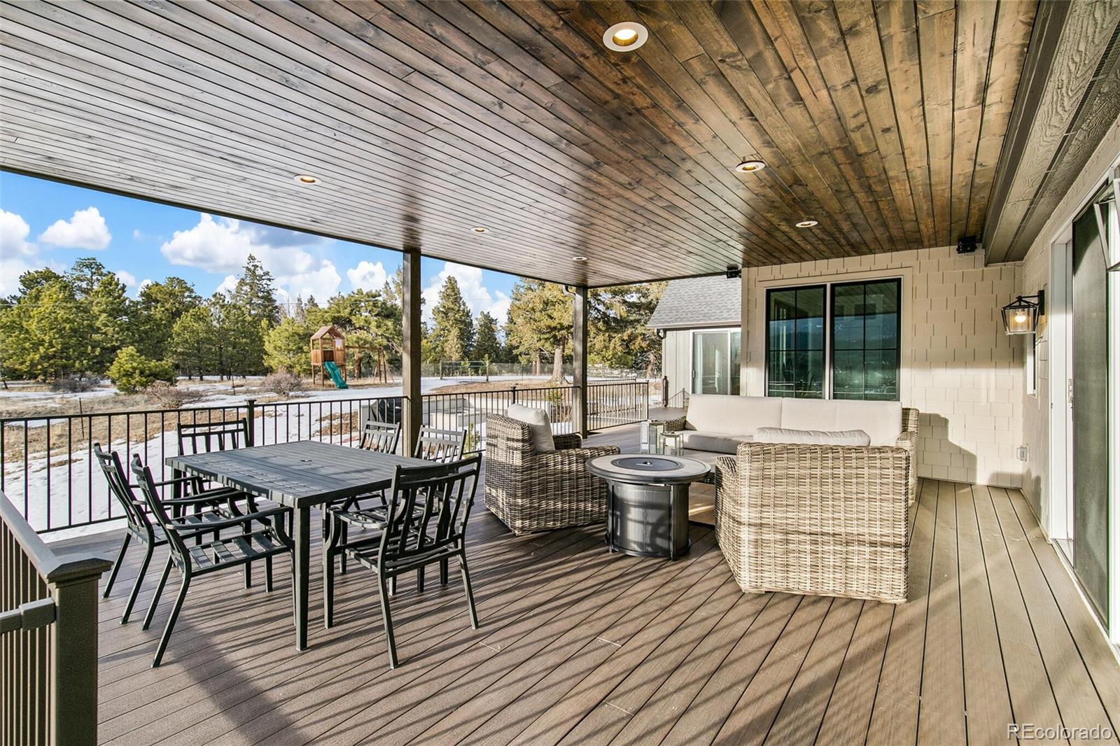 1128 County Road 65 Evergreen, CO 80439 - Photo 29 of 40 a view of deck with table and chairs and wooden floor
