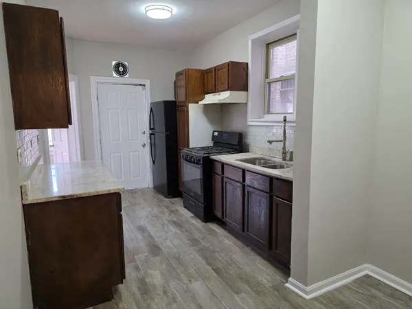 a kitchen with stainless steel appliances a sink stove and refrigerator