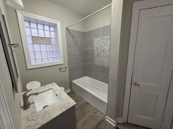 a bathroom with a tub sink and mirror