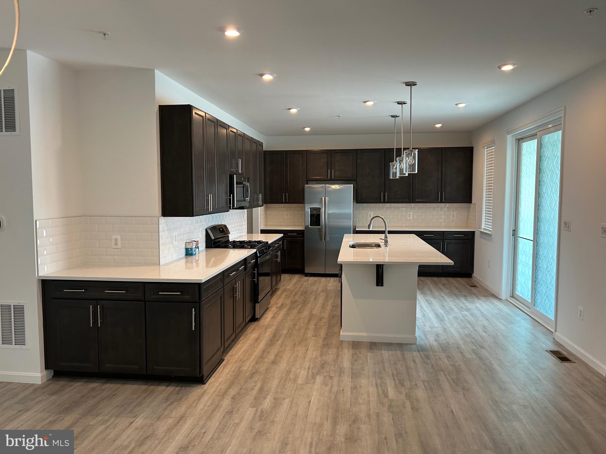 2703 Grasshopper Drive Odenton, MD 21113 - Photo 12 of 14 a large white kitchen with a large counter top a sink a window and stainless steel appliances