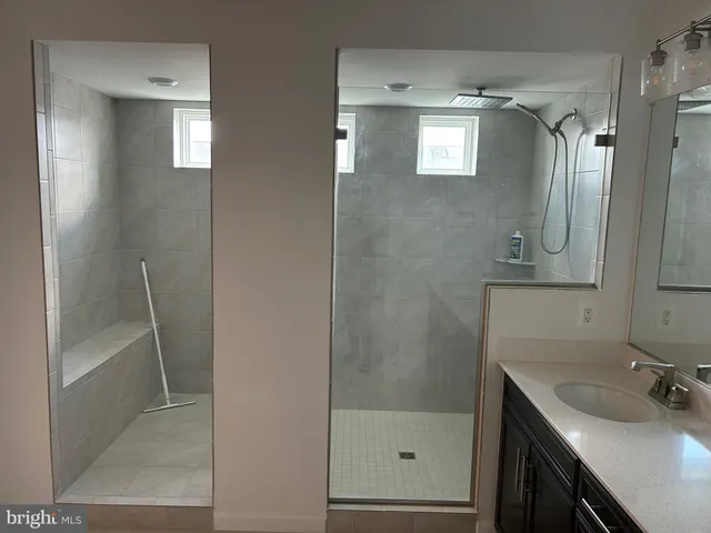 a bathroom with a shower sink and mirror