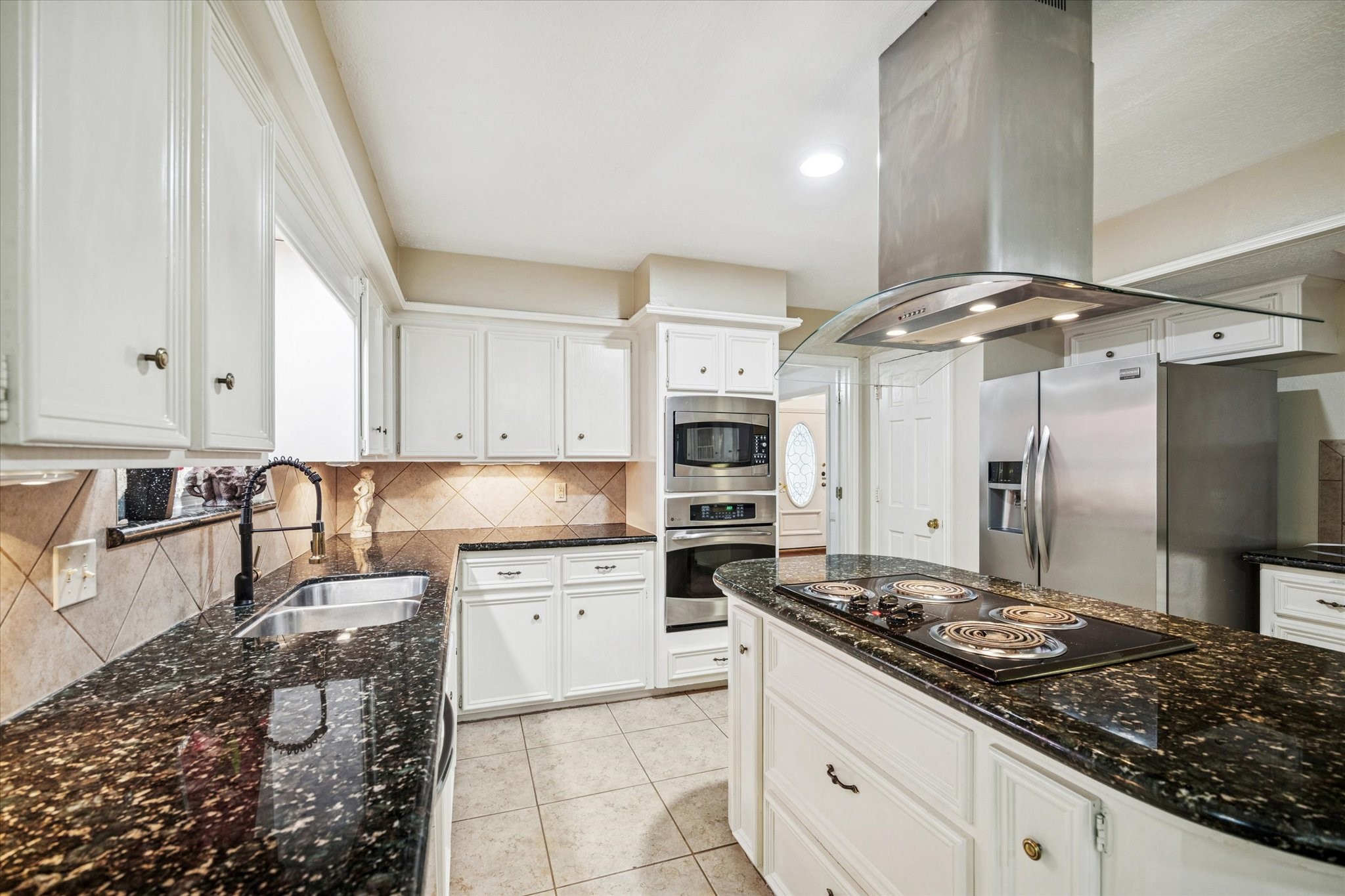 6723 Apple Valley Lane Houston, TX 77069 - Photo 11 of 25 a kitchen with a stove a sink and a refrigerator