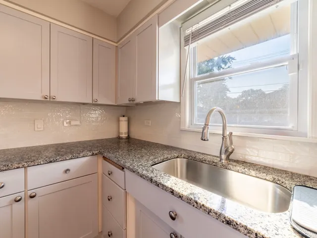 a kitchen with granite countertop a sink and cabinets