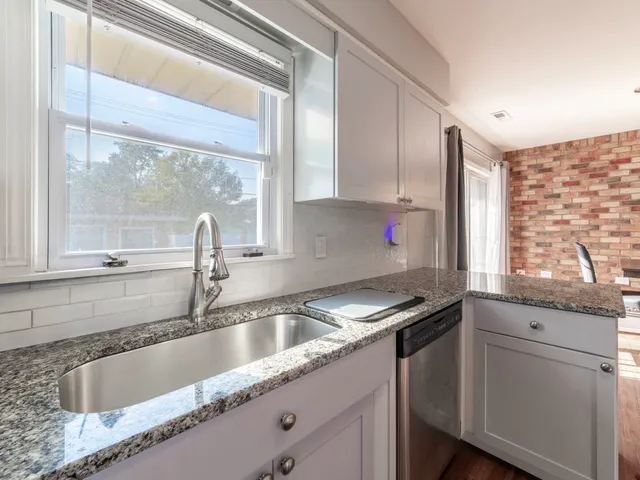 a kitchen with granite countertop a sink and a window