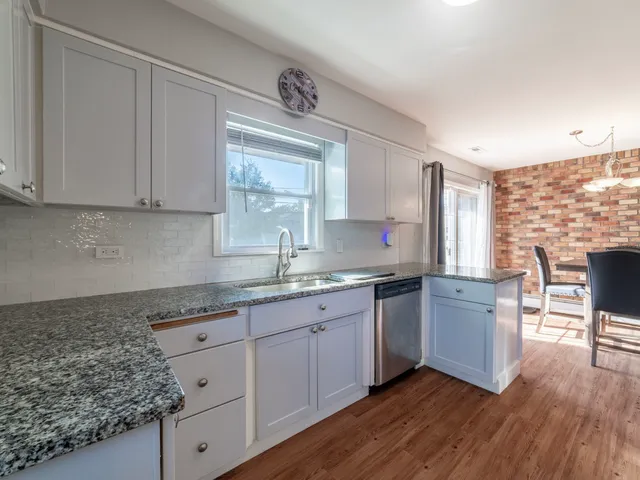 a kitchen with granite countertop cabinets stainless steel appliances a sink and a window