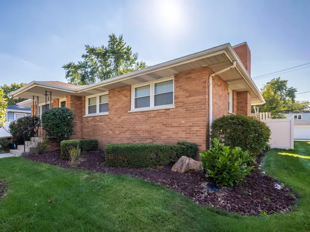 a view of a house with a yard and potted plants