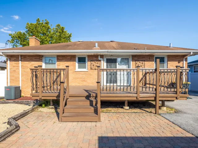 a view of a house with wooden deck and furniture
