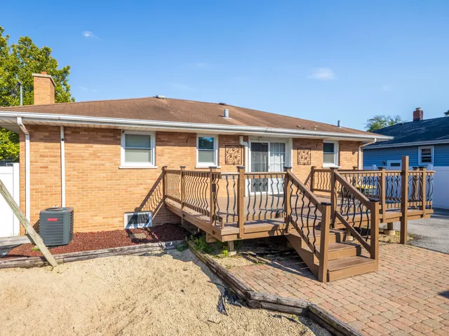 a view of a house with wooden deck and furniture
