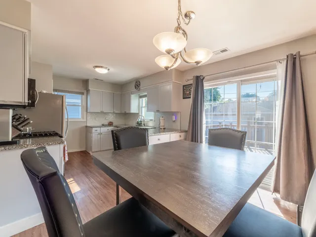 a view of a dining room and livingroom with furniture wooden floor a chandelier