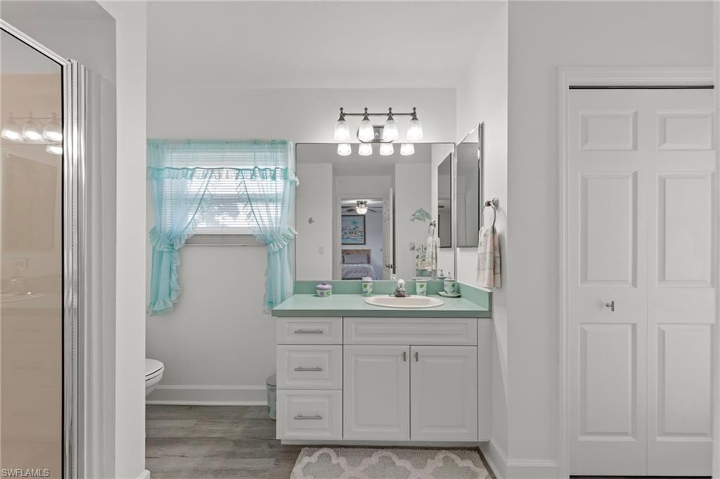 13541 Stringfellow Road Bokeelia, FL 33922 - Photo 24 of 49 a bathroom with a double vanity sink and mirror