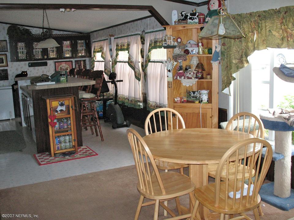 7260 Gas Line Road Keystone Heights, FL 32656 - Photo 3 of 5 a view of a dining room with furniture and a chandelier