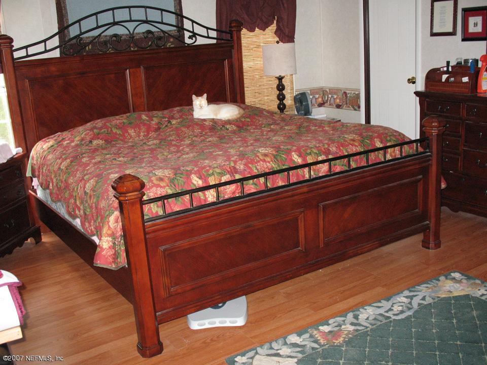 7260 Gas Line Road Keystone Heights, FL 32656 - Photo 4 of 5 a bed sitting in a bedroom next to a cabinet