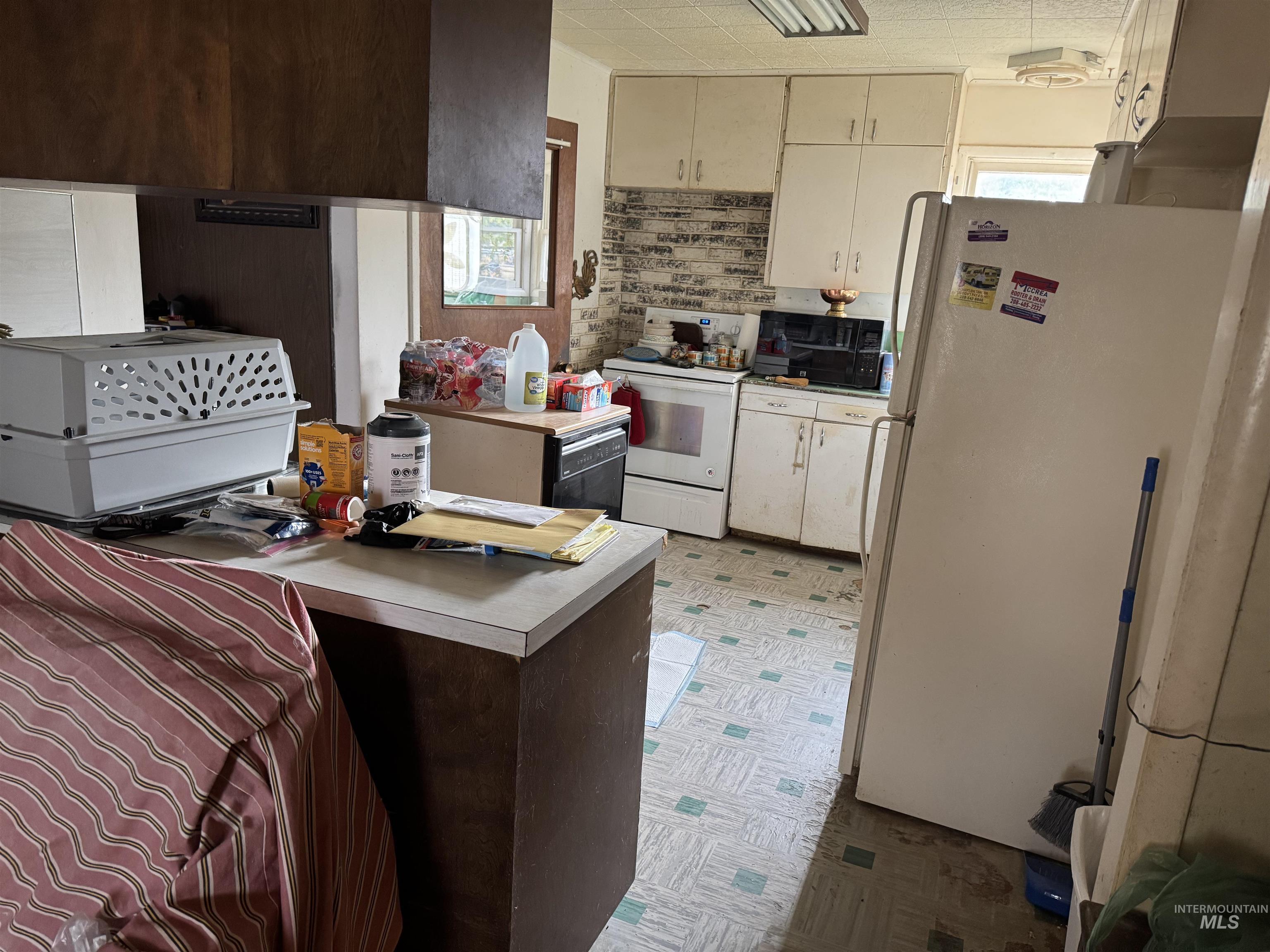 416 North 2nd Street Nyssa, OR 97913 - Photo 7 of 24 Kitchen featuring healthy amount of natural light, white appliances, light flooring, and light countertops