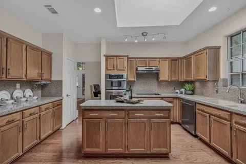 a kitchen with a sink stove cabinets and window