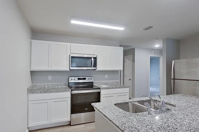 a kitchen with a sink stove and refrigerator