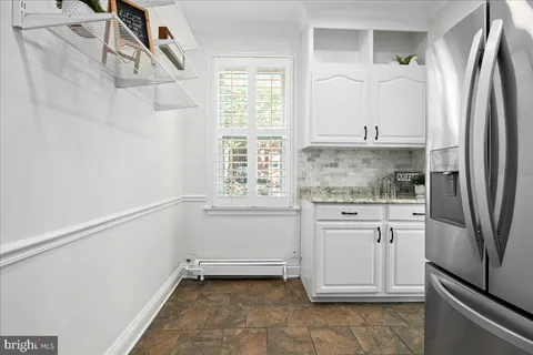 a kitchen with white cabinets and a refrigerator