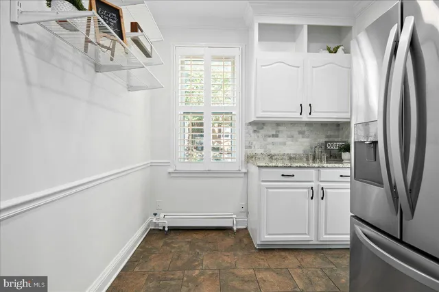 a kitchen with white cabinets and a refrigerator
