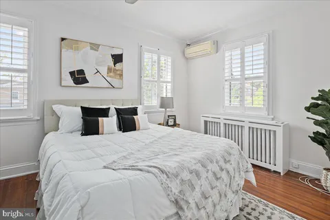 a bedroom with bed and wooden floor