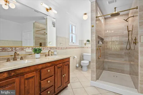 a bathroom with a shower sink vanity mirror and toilet