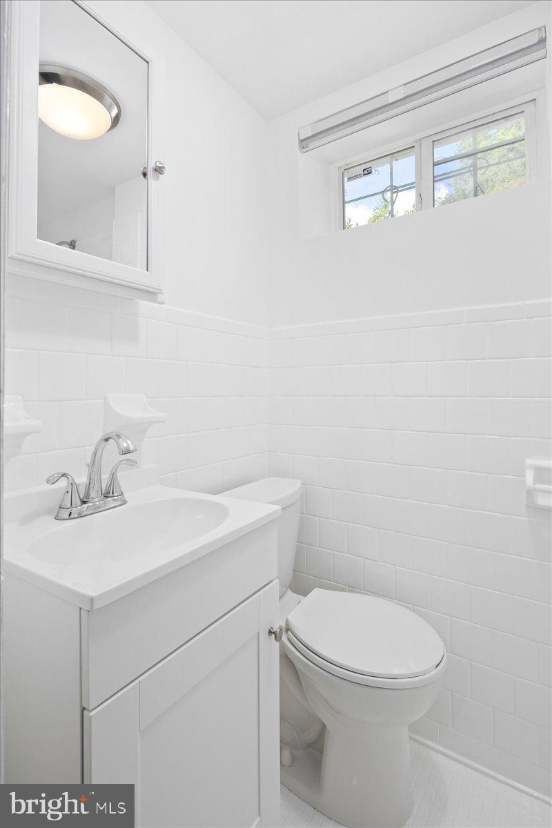 6411 7th Street Northwest Washington, DC 20012 - Photo 29 of 35 a bathroom with a sink a toilet and mirror