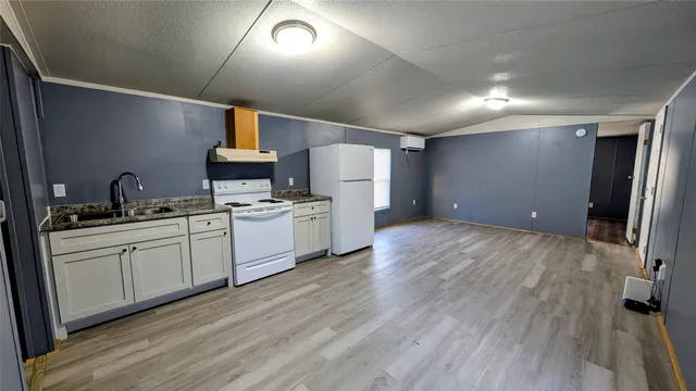 a kitchen with a wooden floor cabinets and stainless steel appliances