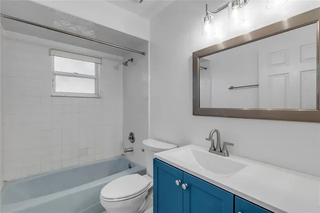 a bathroom with a toilet a sink a mirror and vanity