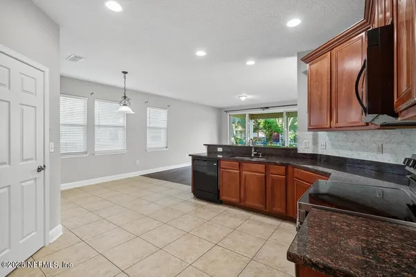 a kitchen with stainless steel appliances granite countertop a sink and a stove top oven with wooden floor