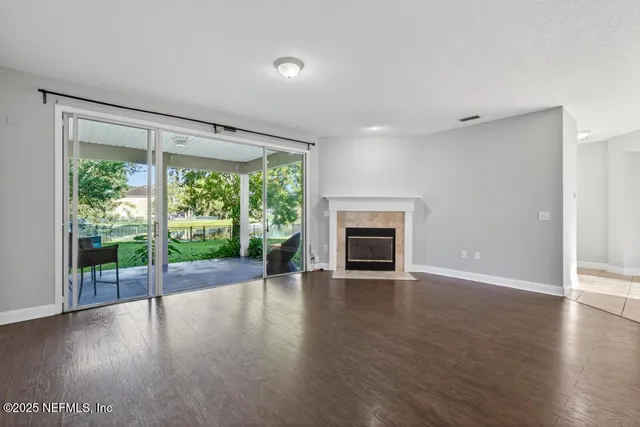 a view of empty room with wooden floor and fireplace