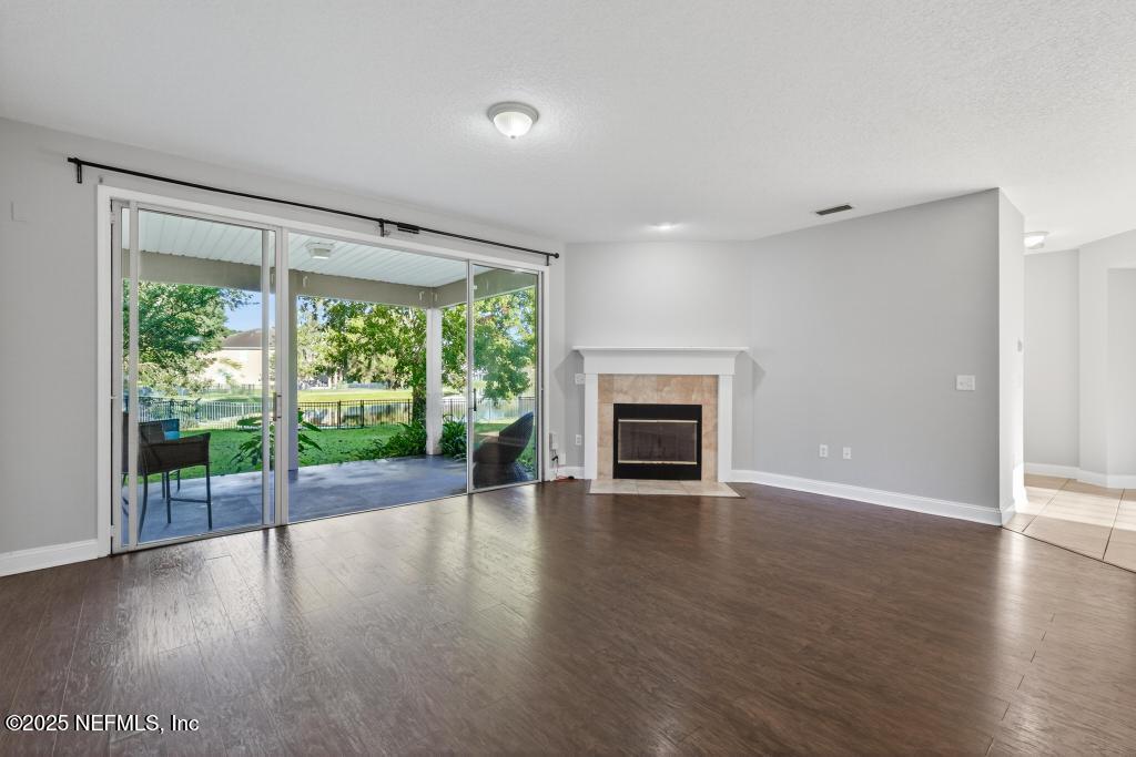 612 Spruce Creek Road St. Johns, FL 32259 - Photo 16 of 50 a view of empty room with wooden floor and fireplace