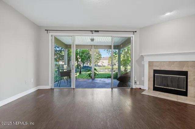 a view of empty room with wooden floor and fireplace