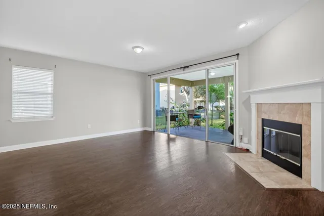 a view of an empty room with a fireplace and a window