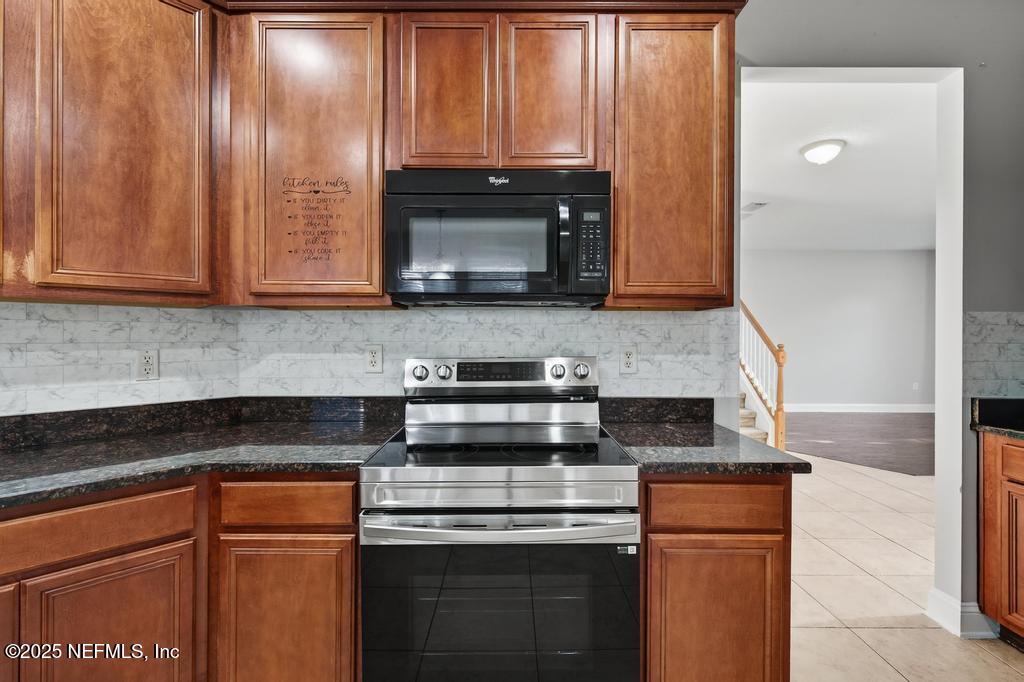 612 Spruce Creek Road St. Johns, FL 32259 - Photo 22 of 50 a kitchen with granite countertop cabinets stainless steel appliances and a counter space