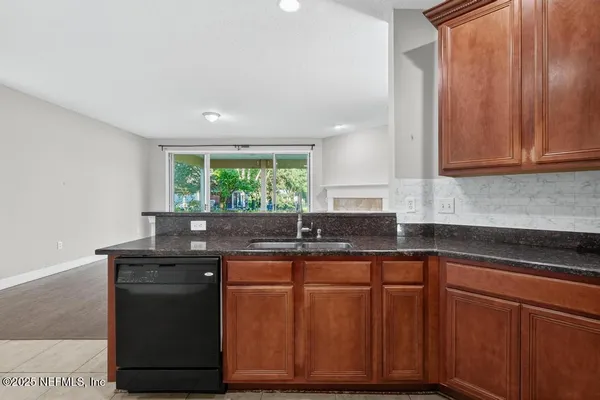 a kitchen with granite countertop wooden cabinets and a sink