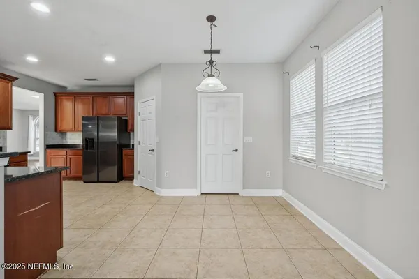 a view of a kitchen with refrigerator and windows