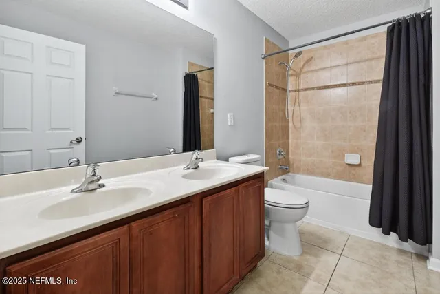a bathroom with a double vanity sink toilet mirror and bathtub