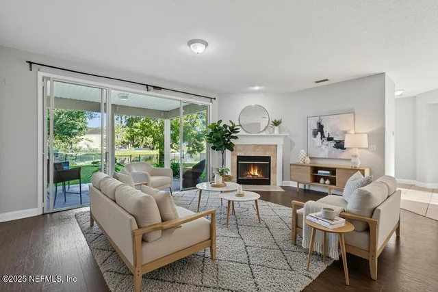 a living room with furniture a fireplace and a large window