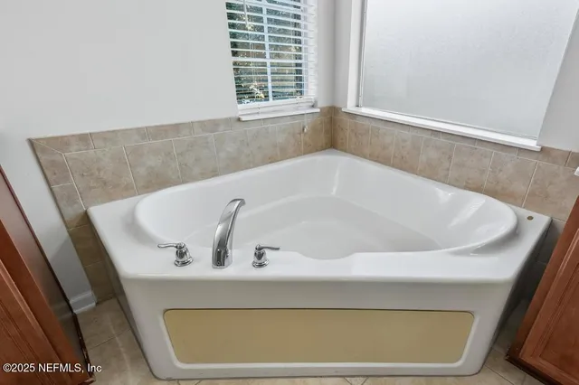a bath tub sitting in a bathroom next to a window