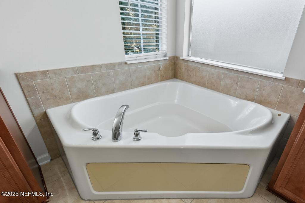 612 Spruce Creek Road St. Johns, FL 32259 - Photo 37 of 50 a bath tub sitting in a bathroom next to a window