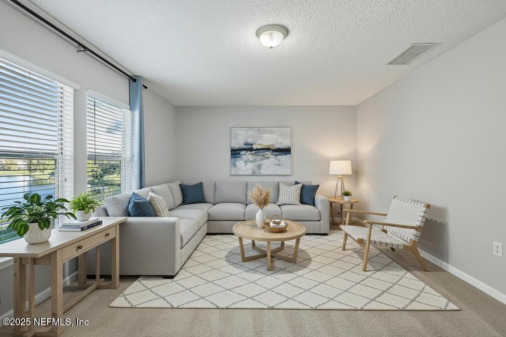 612 Spruce Creek Road St. Johns, FL 32259 - Photo 9 of 50 a living room with furniture and a large window