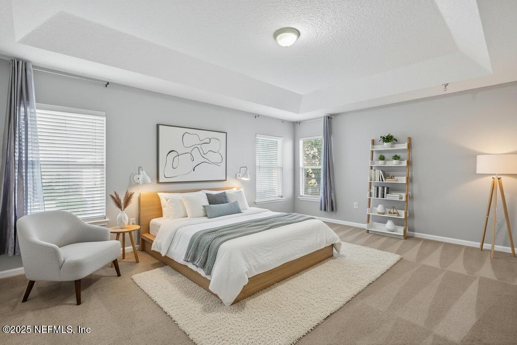 612 Spruce Creek Road St. Johns, FL 32259 - Photo 10 of 50 a spacious bedroom with a bed a couch and a window