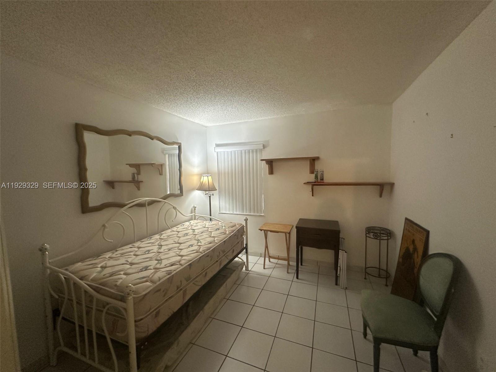 8326 Southwest 10th Terrace Miami, FL 33144 - Photo 6 of 10 a bedroom with a bed and chair