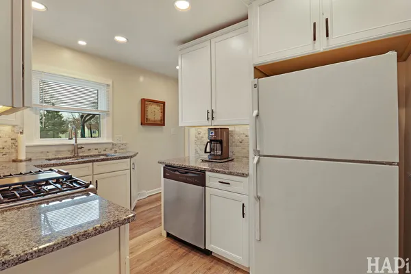a kitchen with a refrigerator a stove top oven and a sink