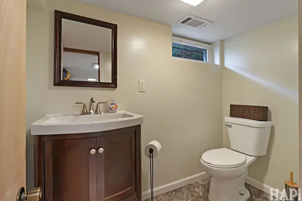 a bathroom with a toilet a sink and mirror