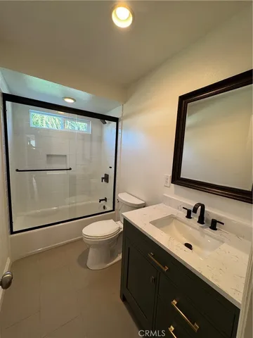 a bathroom with a toilet a sink a mirror and shower