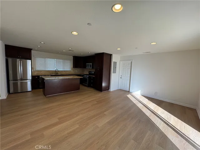 a view of kitchen with refrigerator and a sink
