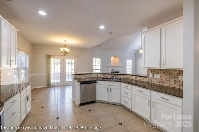 a kitchen with granite countertop white cabinets and white appliances